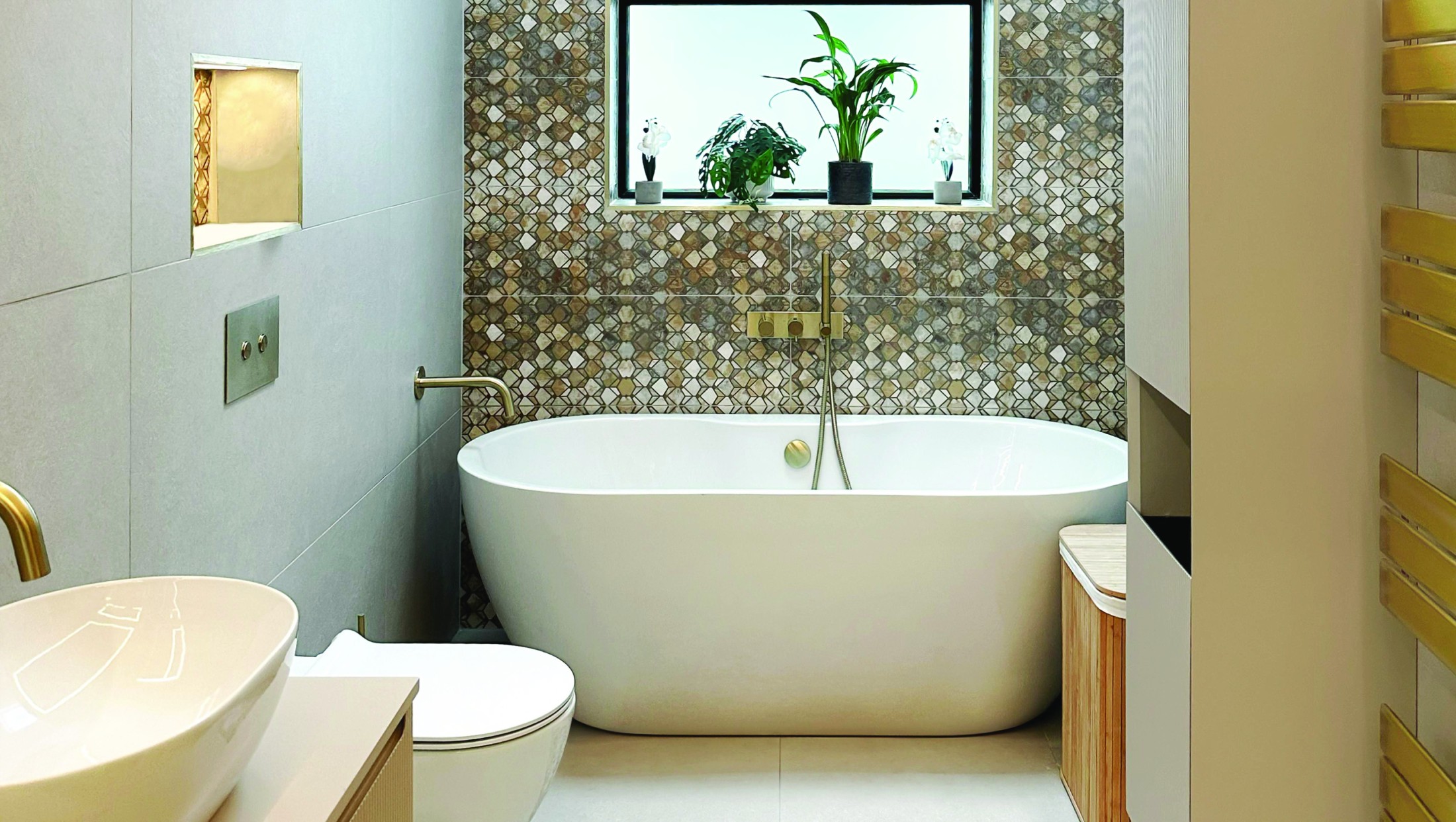 Freestanding bath with a textured feature wall and warm brass details